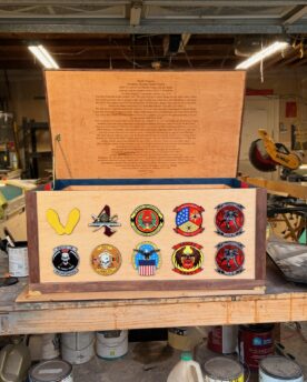 Custom military footlocker with service emblems and a natural wood finish